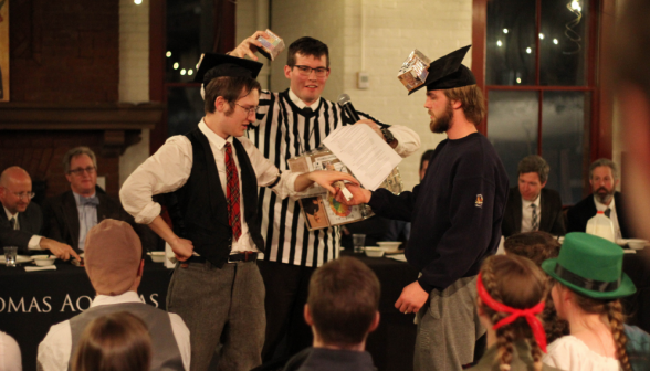 The ref attaches cubes to team leader mortarboards