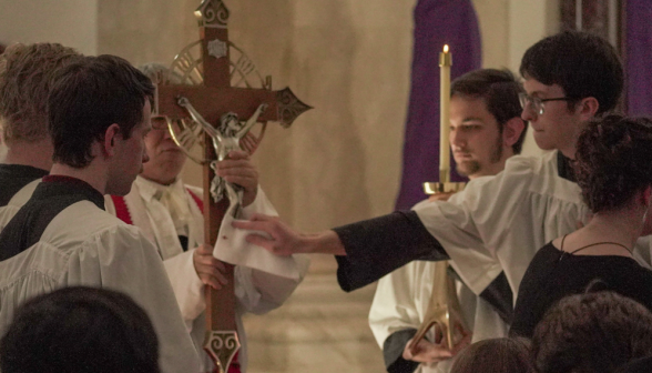 A server wipes off the cross