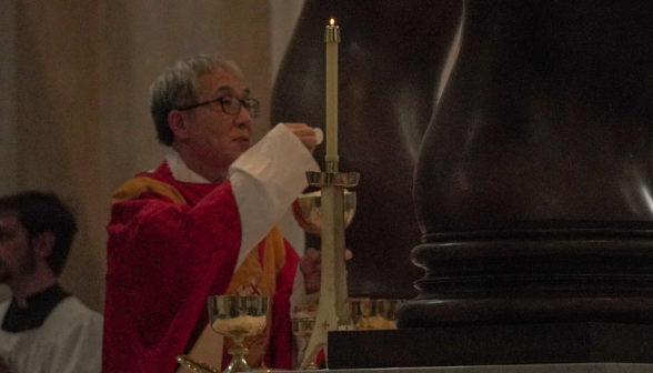 Fr. Chung holds up the Eucharist