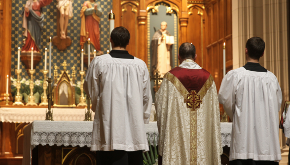 Fr. Markey stands before the now-illuminated altar