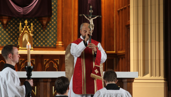 Fr. Viego holds up the crucifix