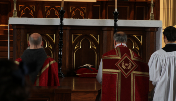 The priests kneeling before the altar