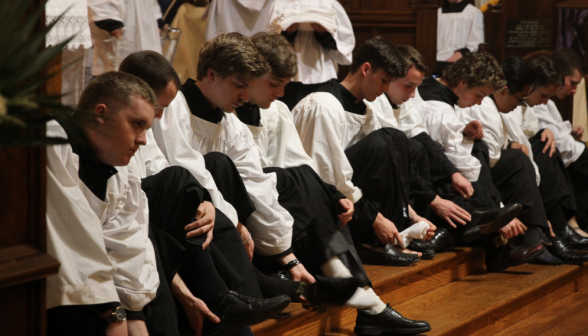 The altar servers remove their shoes for the washing of the feet