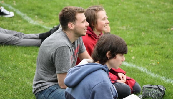 Three watch, seated in the grass