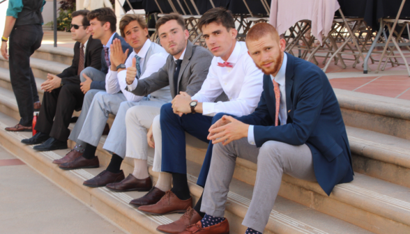 Six men pose, seated on the steps of the Chapel