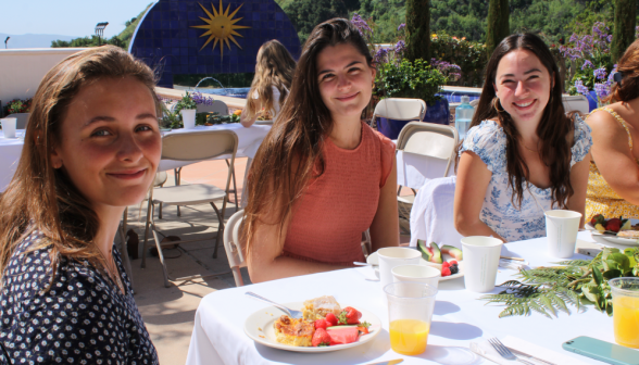 Three pose at a table