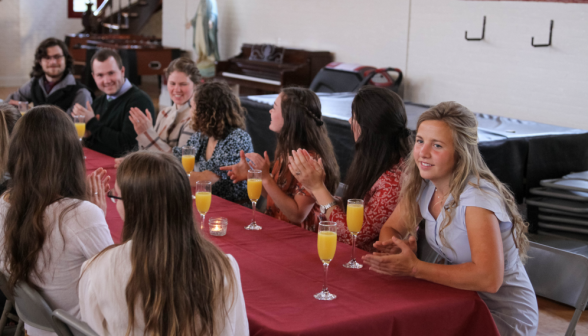 Students at a table applaud