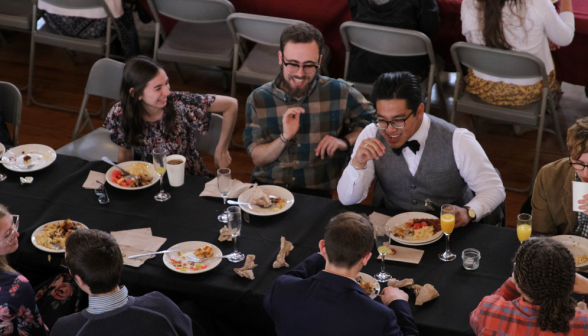 Students laugh and chat at one of the tables