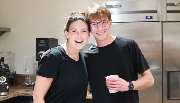 Two pose together in the coffee shop kitchen