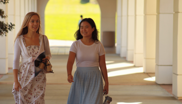 Two walk together along the arcade