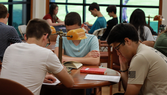 Three study at a table