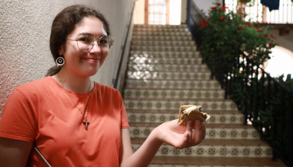 A student smiles for the camera, s'more in hand