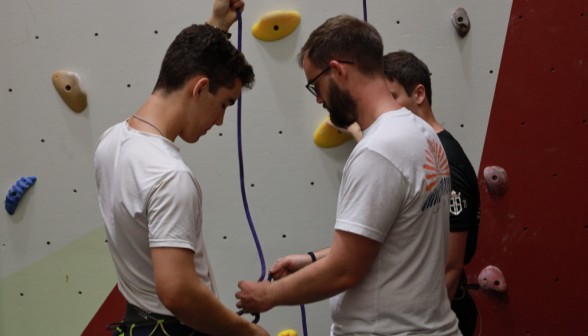 Two put on equipment to do rock climbing