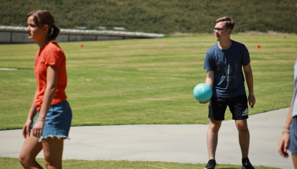 A student about to serve the volleyball