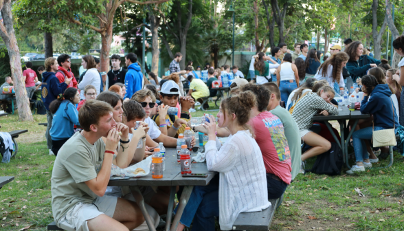 Long shot of students at picnic tables