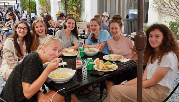 Seven at an outdoor lunch table