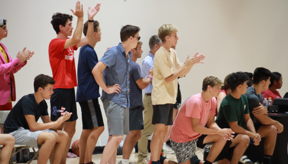 Spectators applaud from the sidelines