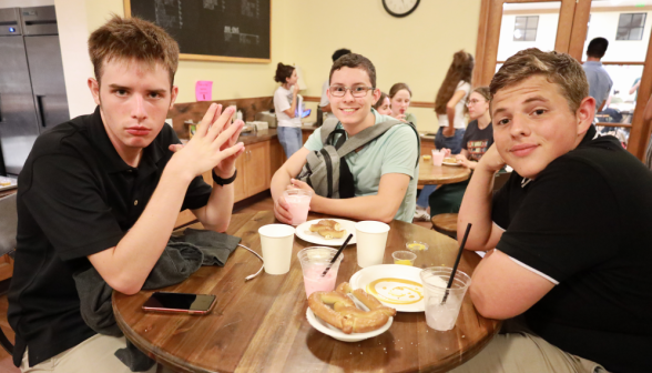 Three pose at a table