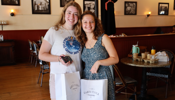 Two pose together with their bags from the Santa Paula Trading Co