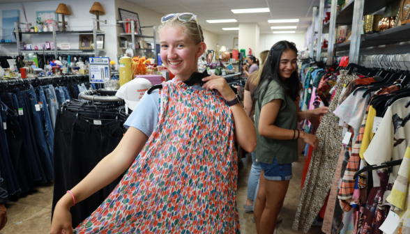 A student holds up a multi-colored skirt