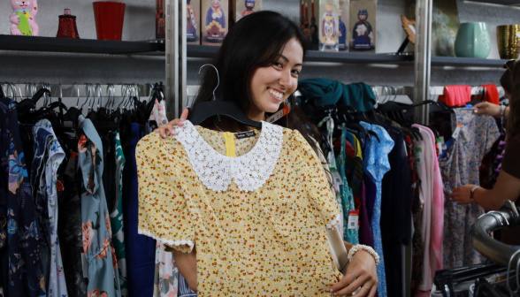 A student holds up a dress