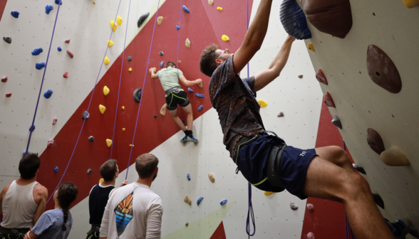 Students climb on the rock wall