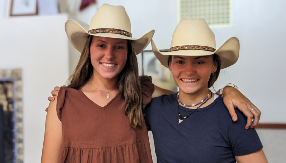 Two pose in cowboy hats