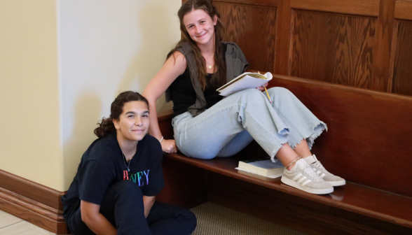 Two smile for the camera in the classroom building hallway