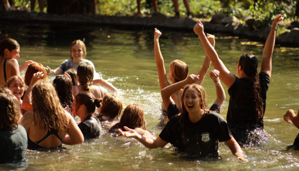 A student in the pond laughs as the struggle takes place