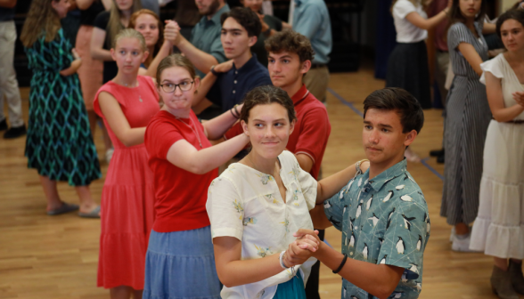 A line of student pairs in waltz position