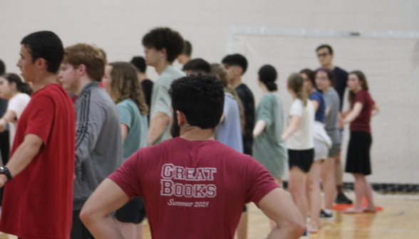 Students line up holding hands in the gym