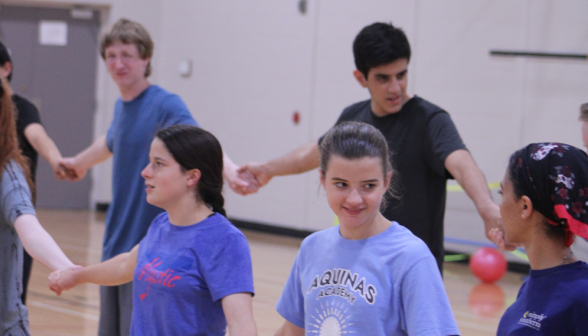 Students are in two ranks, holding hands