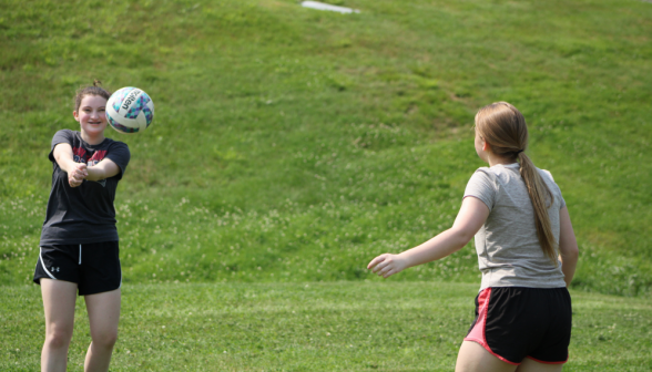 Two students volley a volleyball