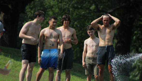 Five men prepare to take the water slide