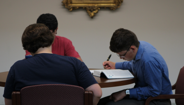 Three study at a table