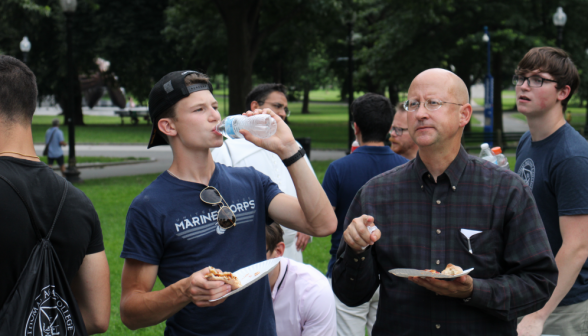 Mr. Froula chats with a student over pizza