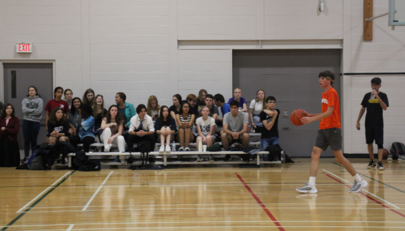 A student with the ball runs past the onlookers