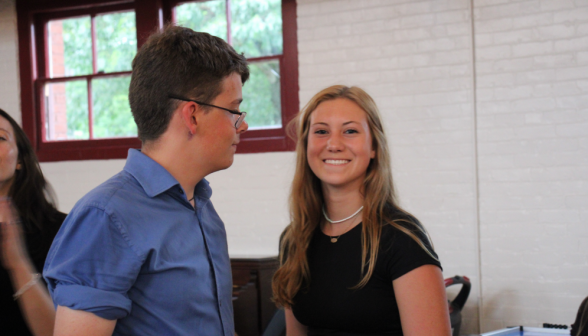 A student pair; one smiles for the camera