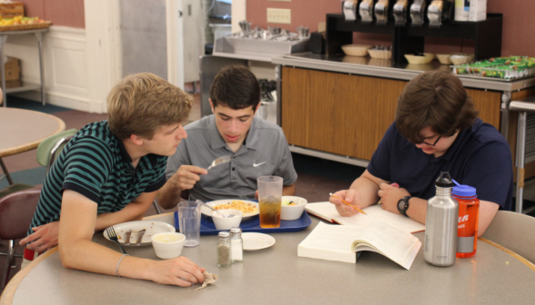 One eats lunch while two discuss Euclid on either side of him