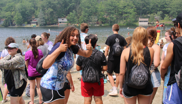 A student gives two thumbs-up to the camera