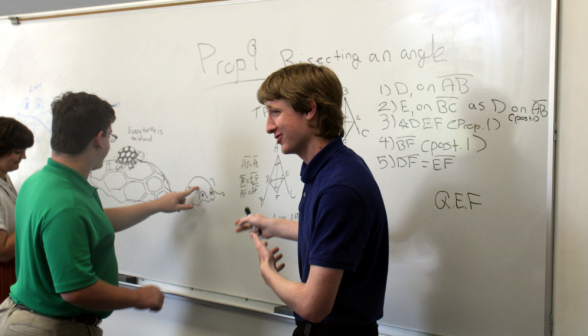 A student draws a turtle while another admires it