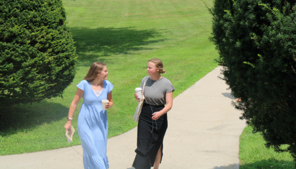 Two chat on the path to the classroom building