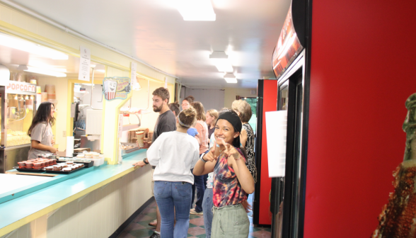 A student makes finger guns at the camera in the snack shop