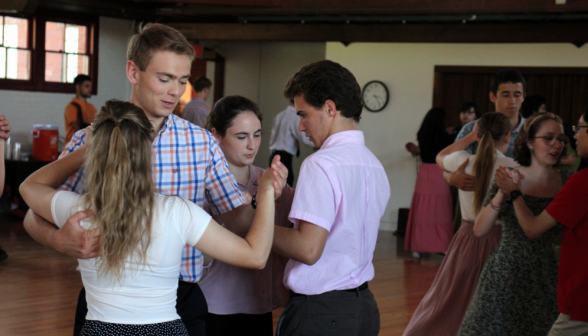 Two couples dance