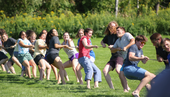 A group of young men and women playing tug of war.