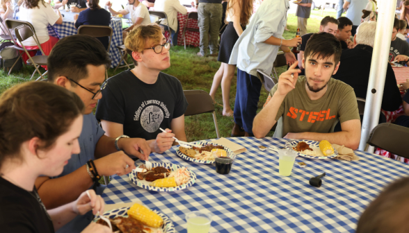 A group of young men and women eating.