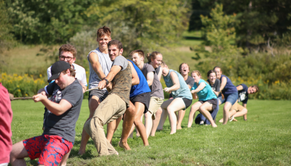 A group of young men and women playing tug of war.