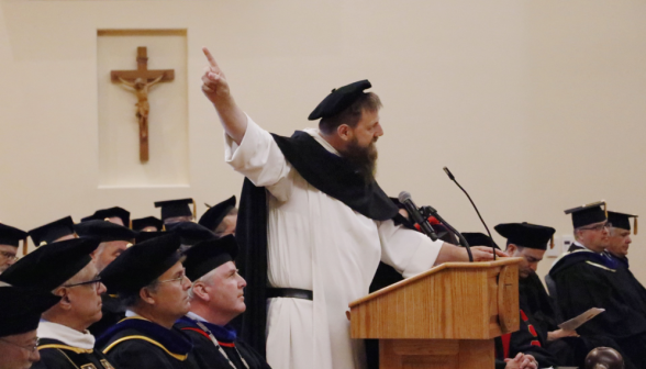 The visiting priest addresses the students