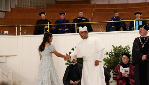 Fr. Miguel shakes the hand of a freshman