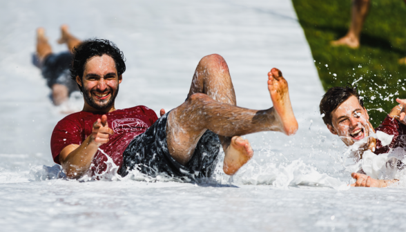 A suave man goes down the slide
